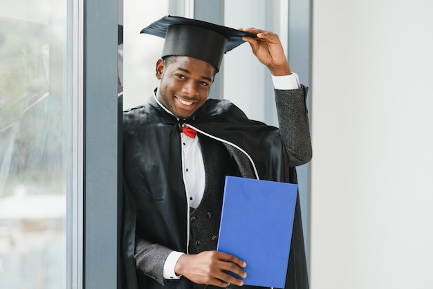 African American graduate holding diploma.