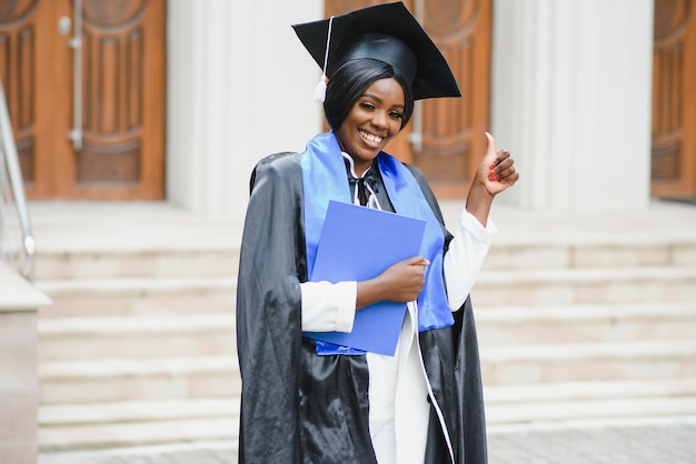 African American graduate holding diploma.