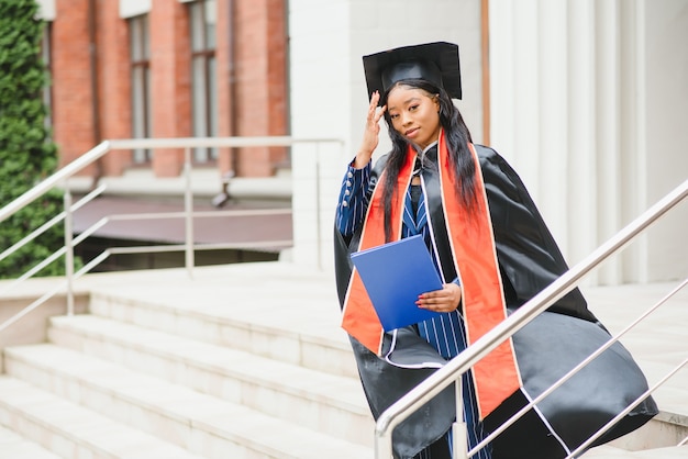 African American graduate holding diploma.