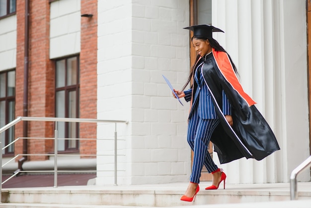 African American graduate holding diploma.