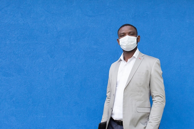 African American in een beschermend masker op een blauwe achtergrond