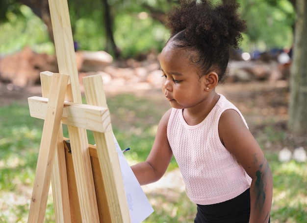 公園で絵を描くアフリカ系アメリカ人の子供の女の子