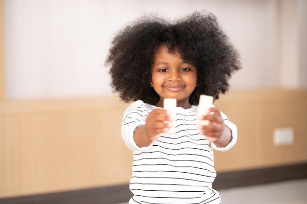 African American kid girl playing with toy at home Young little girl African American