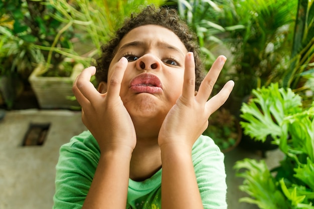 African american kid making faces and having fun in the garden