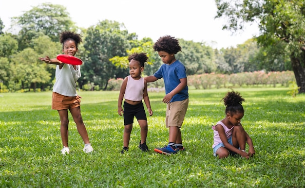 I bambini afroamericani giocano a frisbee nel parco