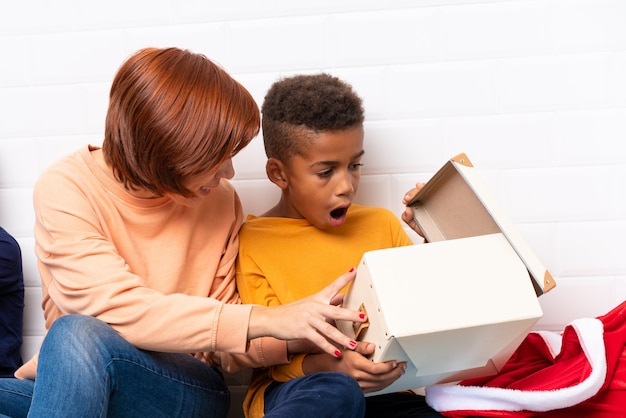 African American kids with their mother among many gifts for christmas holidays