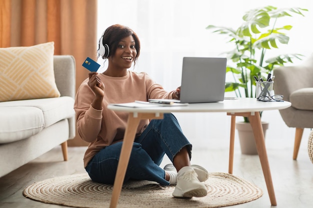 Acquirente di signora afroamericana che acquista online sul laptop a casa