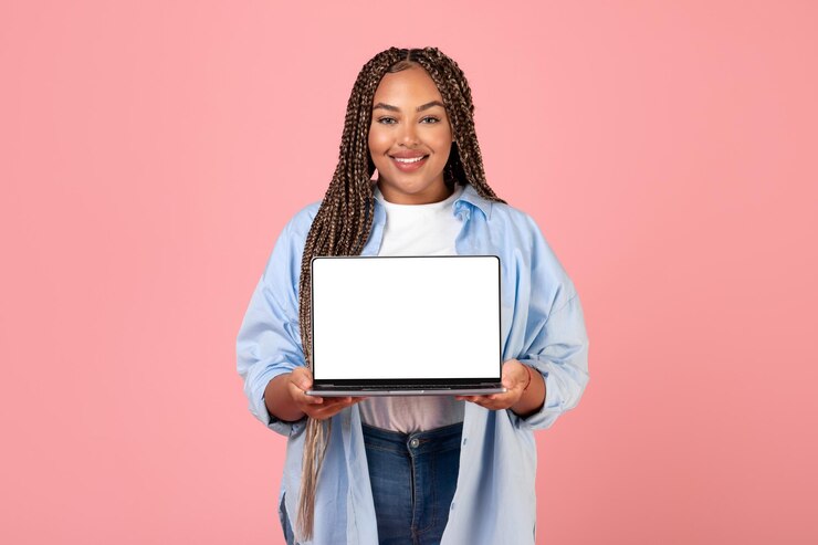 Photo african american lady showing laptop empty screen over pink background