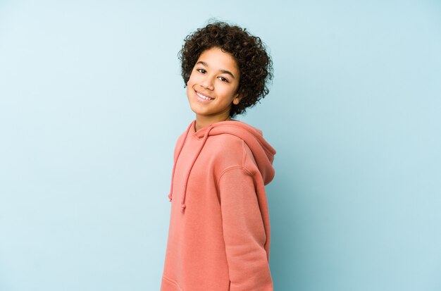 African american little boy isolated looks aside smiling, cheerful and pleasant.