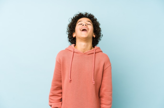 African american little boy isolated relaxed and happy laughing, neck stretched showing teeth.