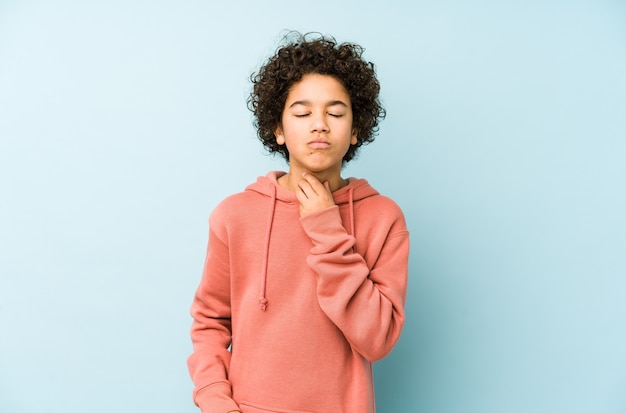 Изолированный афроамериканский маленький мальчик страдает от боли в горле из-за вируса или инфекции.