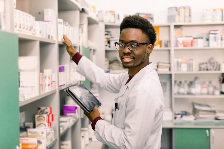 Photo african american male pharmacist using digital tablet during inventory in pharmacy.