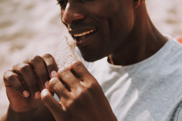 African American Man Bites Sandwich Outdoor