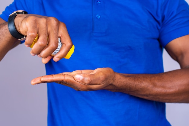 African american man in blue shirt pouring pills from prescription pill bottle