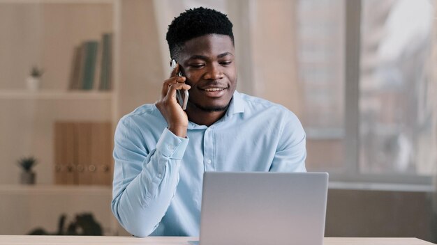 African american man businessman freelancer worker talk chatter on mobile cellphone with client make