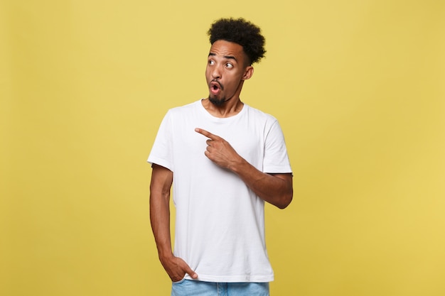 Uomo afroamericano in camicia bianca casuale che ha eccitato sguardo