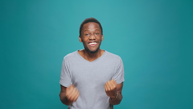 African american man celebrating achievement and success,\
feeling happy and pleased about big win. confident excited person\
cheering after hearing good successful news, doing victory\
celebration.