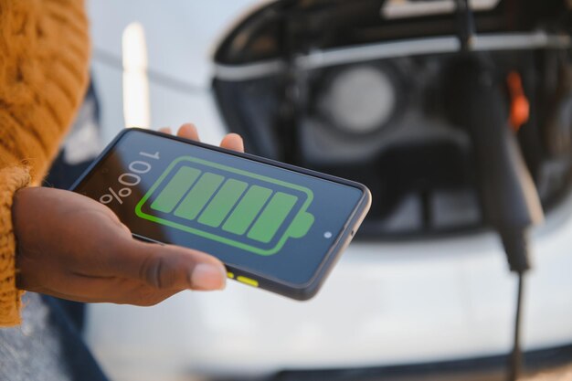 電気自動車を充電しているアフリカ系アメリカ人の男。