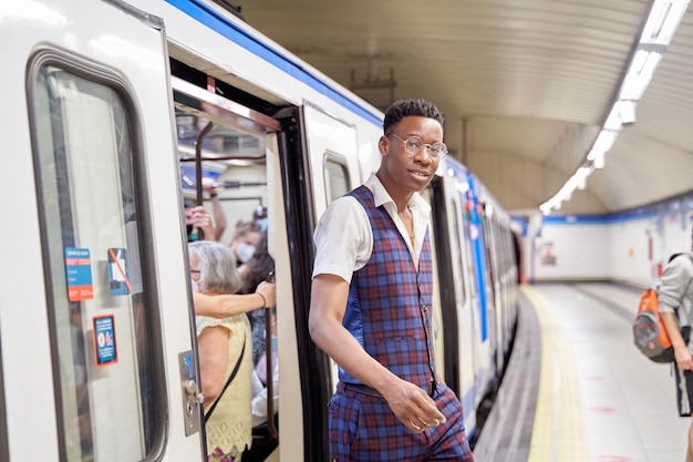地下鉄の電車から降りるアフリカ系アメリカ人男性