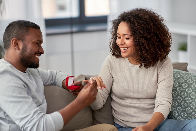 african american man giving woman engagement ring