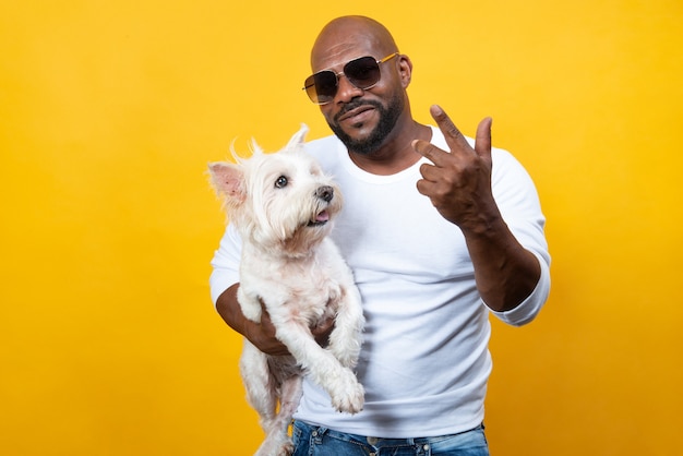 African american man in good physical shape on yellow background with his dog