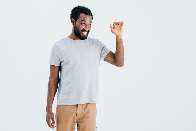 African american man in grey tshirt waving isolated on grey