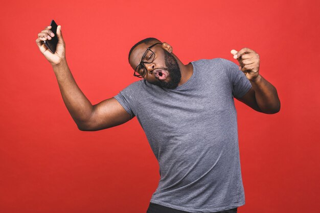 African American man holding smartphone and smiling