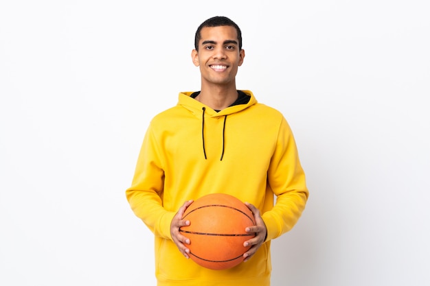 African American man over isolated white wall playing basketball