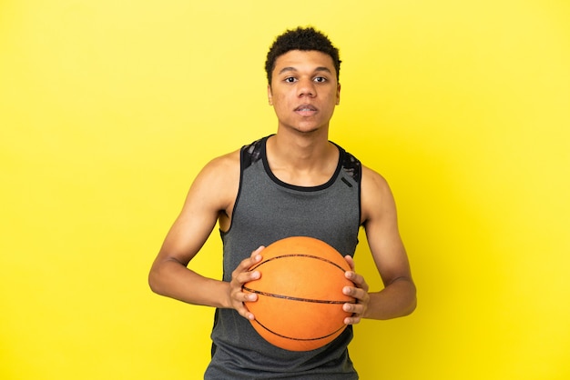 African american man isolated on yellow background playing\
basketball