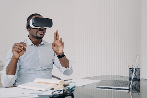 African american man IT engineer developer in VR glasses working with virtual reality at office desk