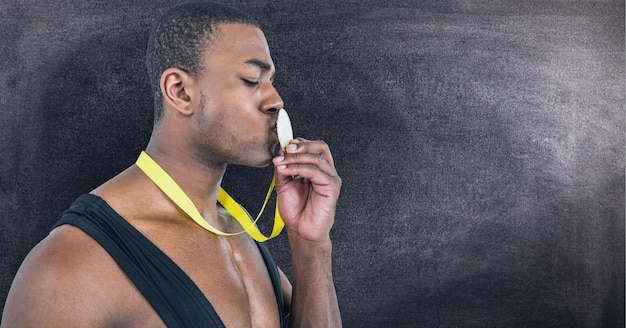Афро-американский мужчина целует медаль на шее против текстурного эффекта на черном фоне