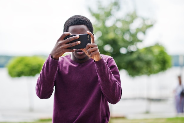 彼の携帯電話で写真を作るアフリカ系アメリカ人の男