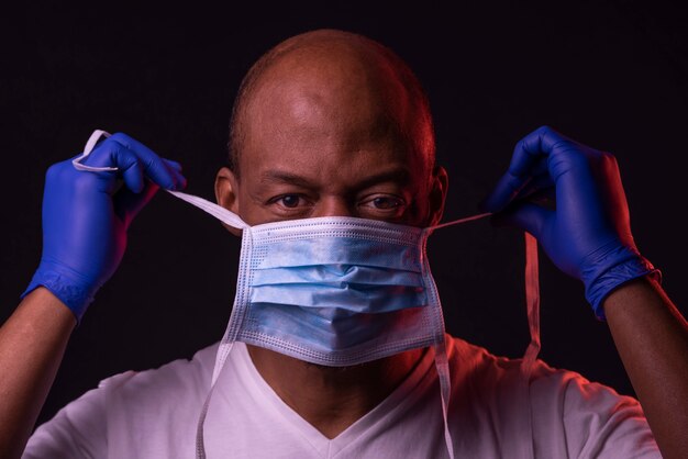 African American man met handschoenen een masker te zetten