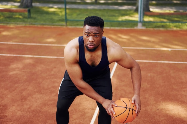 African american man plays basketball on the court outdoors