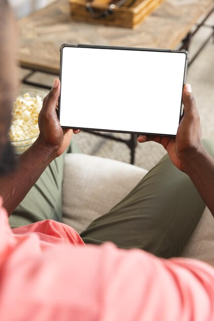 Photo african american man relaxing at home holding blank tablet screen with copy space