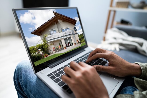 Foto uomo afroamericano che seleziona nuova casa sul computer portatile a casa