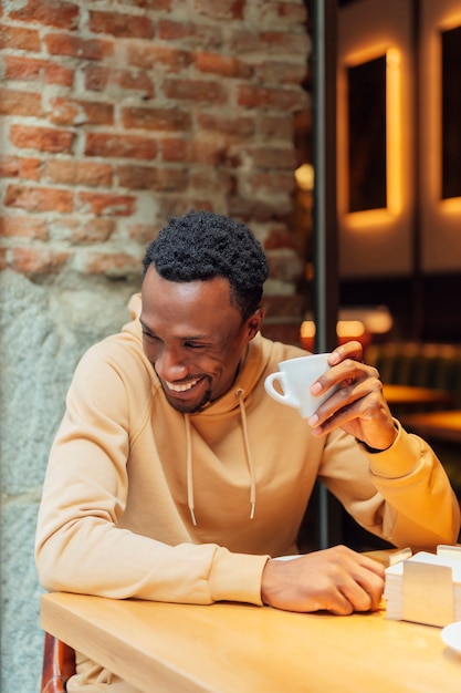 African American man smiling while drinking coffee