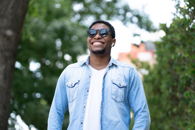 Афро-американский мужчина улыбается, стоя на улице на улице. Городская концепция.