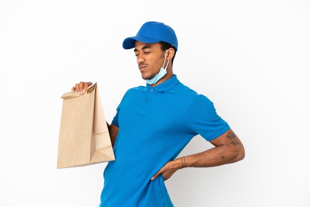 Афро-американский мужчина берет сумку еды на вынос, изолированную на белом фоне, страдает от боли в спине за то, что приложил усилия