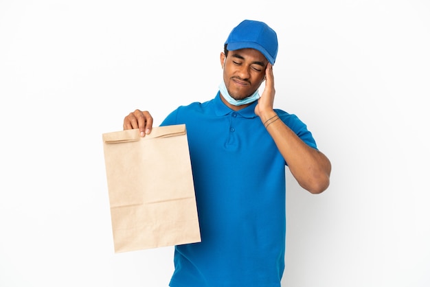 頭痛と白い背景で隔離の持ち帰り用食品の袋を取っているアフリカ系アメリカ人の男