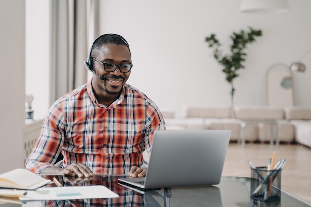 African american man teacher in headset gives online lesson at laptop Elearning distance education