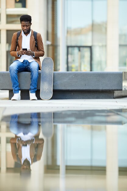 African-American Man Using Smartphone in City