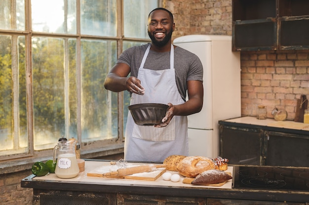 African American man wearing apron and baking