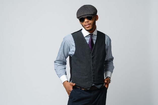 African american man wearing cap, shirt and tie over grey wall