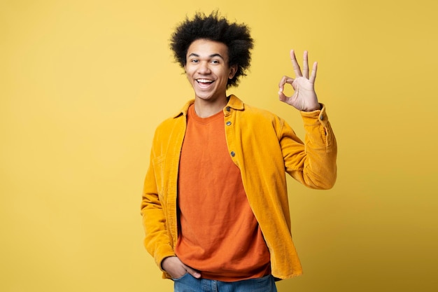 African American man wearing stylish outfit showing ok sign,  isolated on yellow background