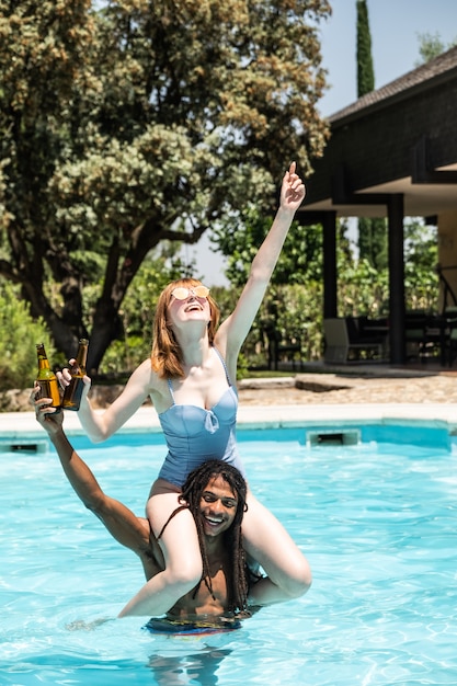 African-American man and white woman playing in a pool.