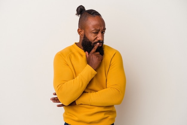 Photo african american man with beard isolated on pink background contemplating, planning a strategy, thinking about the way of a business.