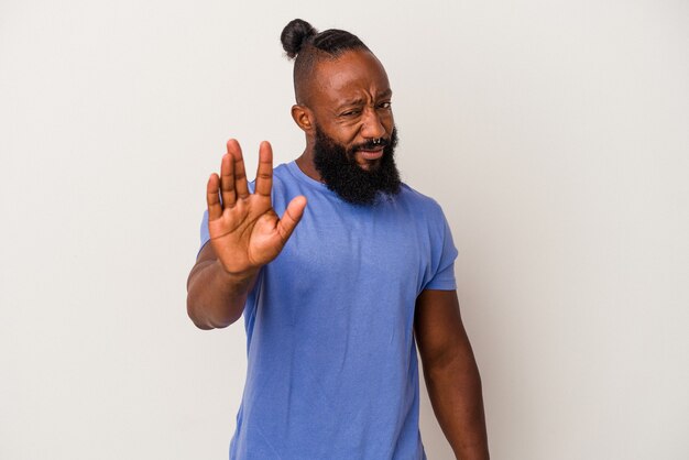 African american man with beard isolated on pink background rejecting someone showing a gesture of disgust.