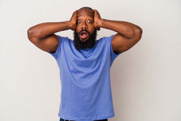African american man with beard isolated on pink background surprised and shocked.