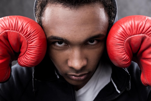 African American man with boxing gloves looking to camera